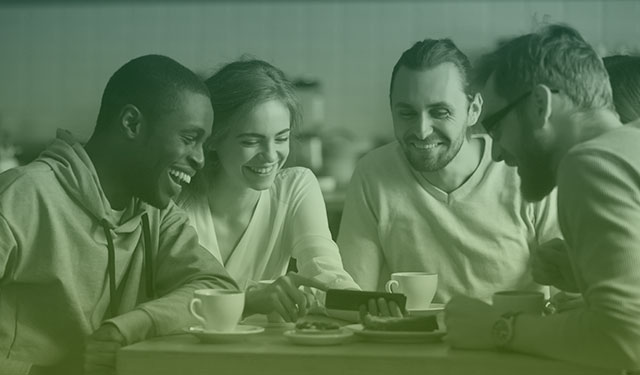 Pessoas entusiasmadas em cafeteria assistindo vídeo em celular