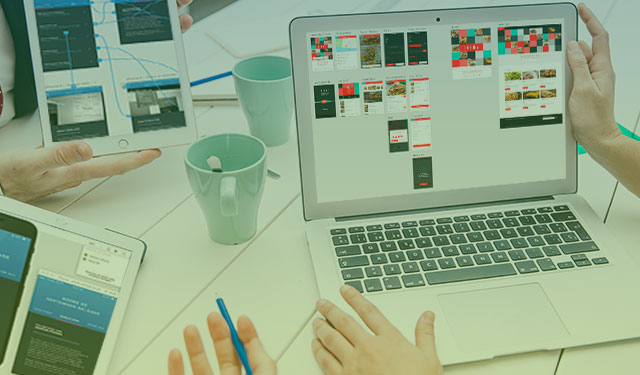 Pessoas prototipando a UX de um site em tablet e computador