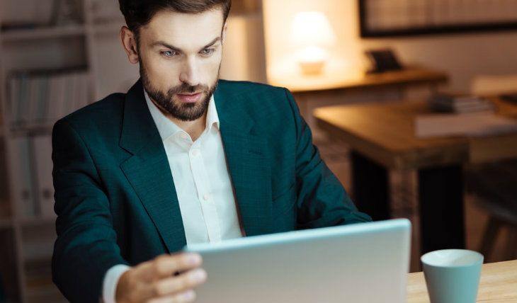 Homem de terno mexendo no computador