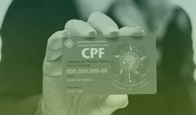 Mulher segurando um cartão exibindo um CPF