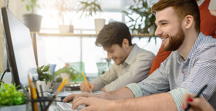 Pessoas em sala de escritório utilizando computador