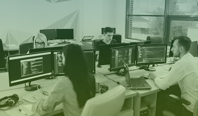 Pessoas trabalhando em computadores dentro de um escritório