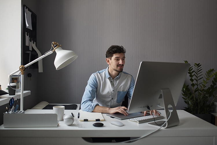 Homem numa sala de escritório utilizando o computador