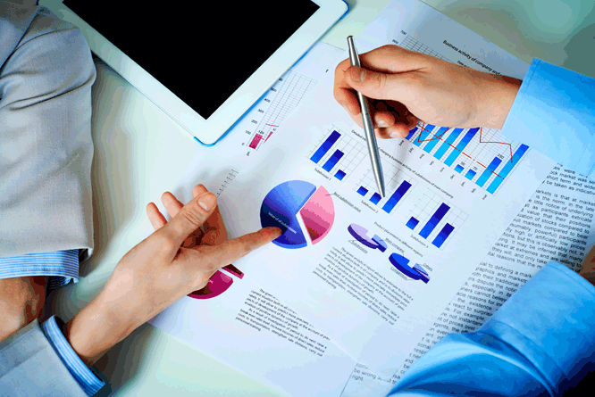 Pessoas analisando gráficos em uma folha