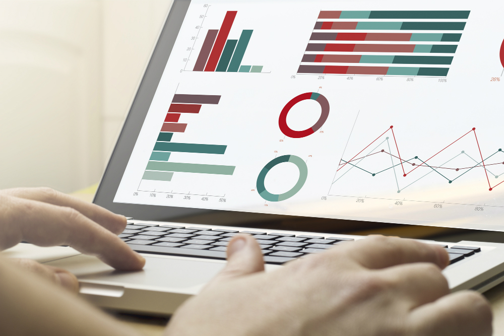 Pessoa utilizando computador com tela exibindo gráficos