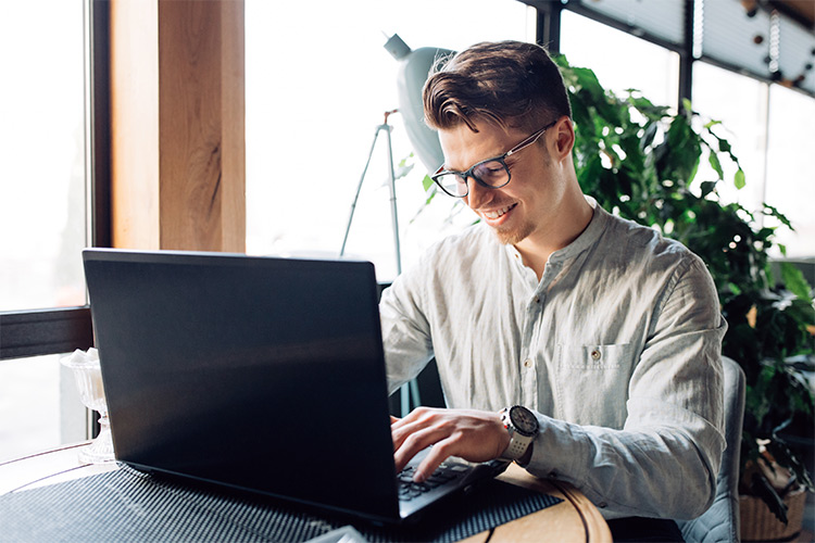 Homem sorrindo utilizando computador