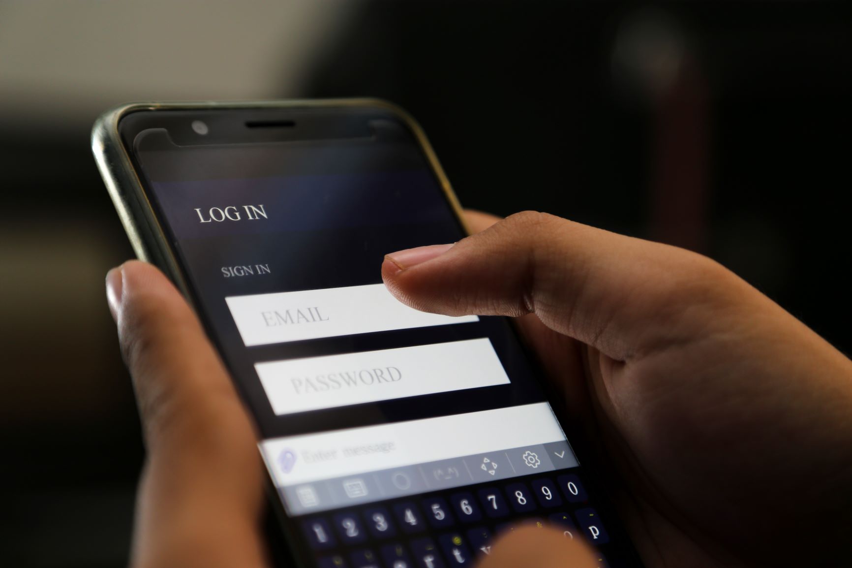 Pessoa utilizando a tela de login de um aplicativo no celular