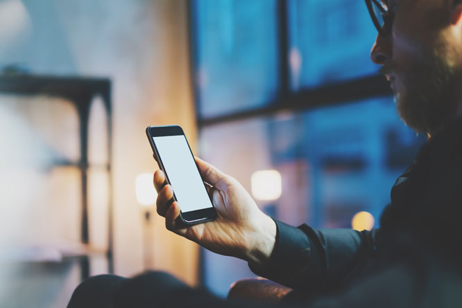 Homem utilizando celular em ambiente social