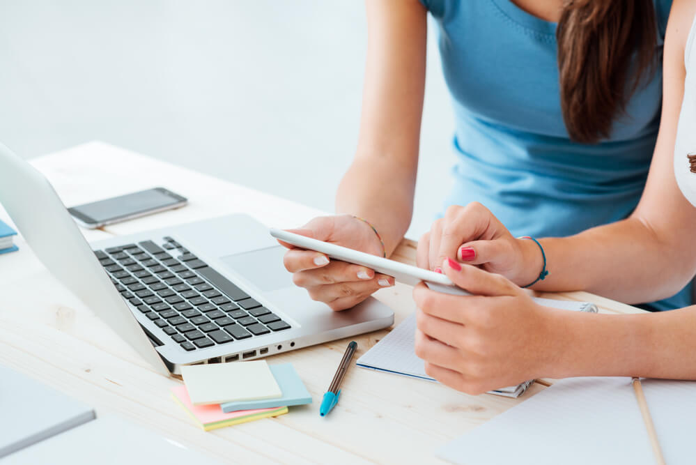 Mulheres utilizado celular em mesa de escritório