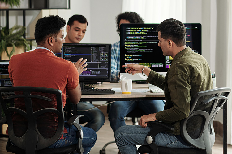 equipe de TI trabalhando em frente a computadores