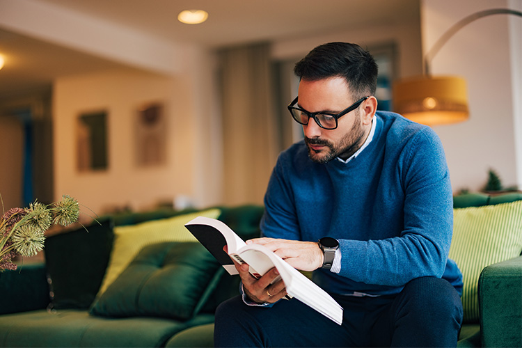 Fotografia de homem lendo livro sobre investimentos