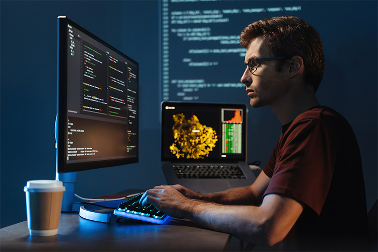 Retrato de perfil de um jovem programador trabalhando em seu computador com a linguagem de programação de Python